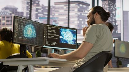 Programátor pri monitoroch s vizualizáciou umelej inteligencie – AI vo firme